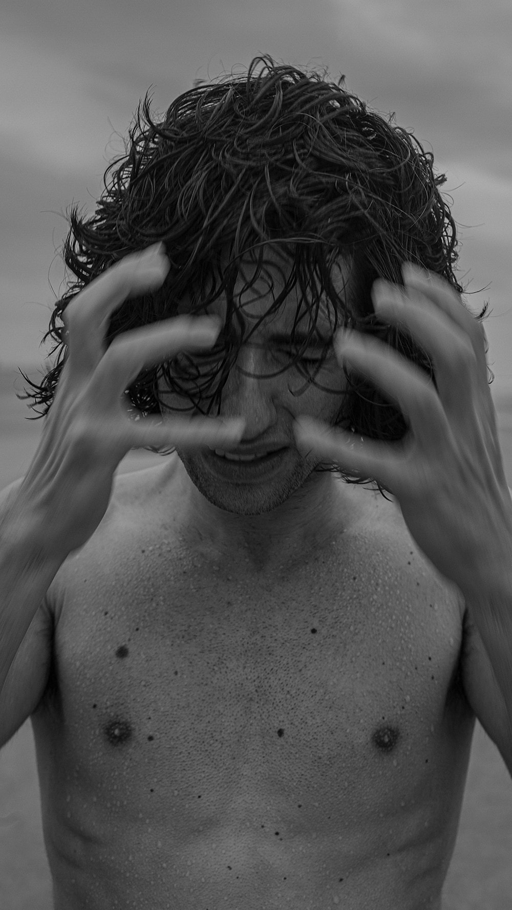 Close in, he drags both wet hands back over his face, the movement blurred, caught between a wince and a smile.