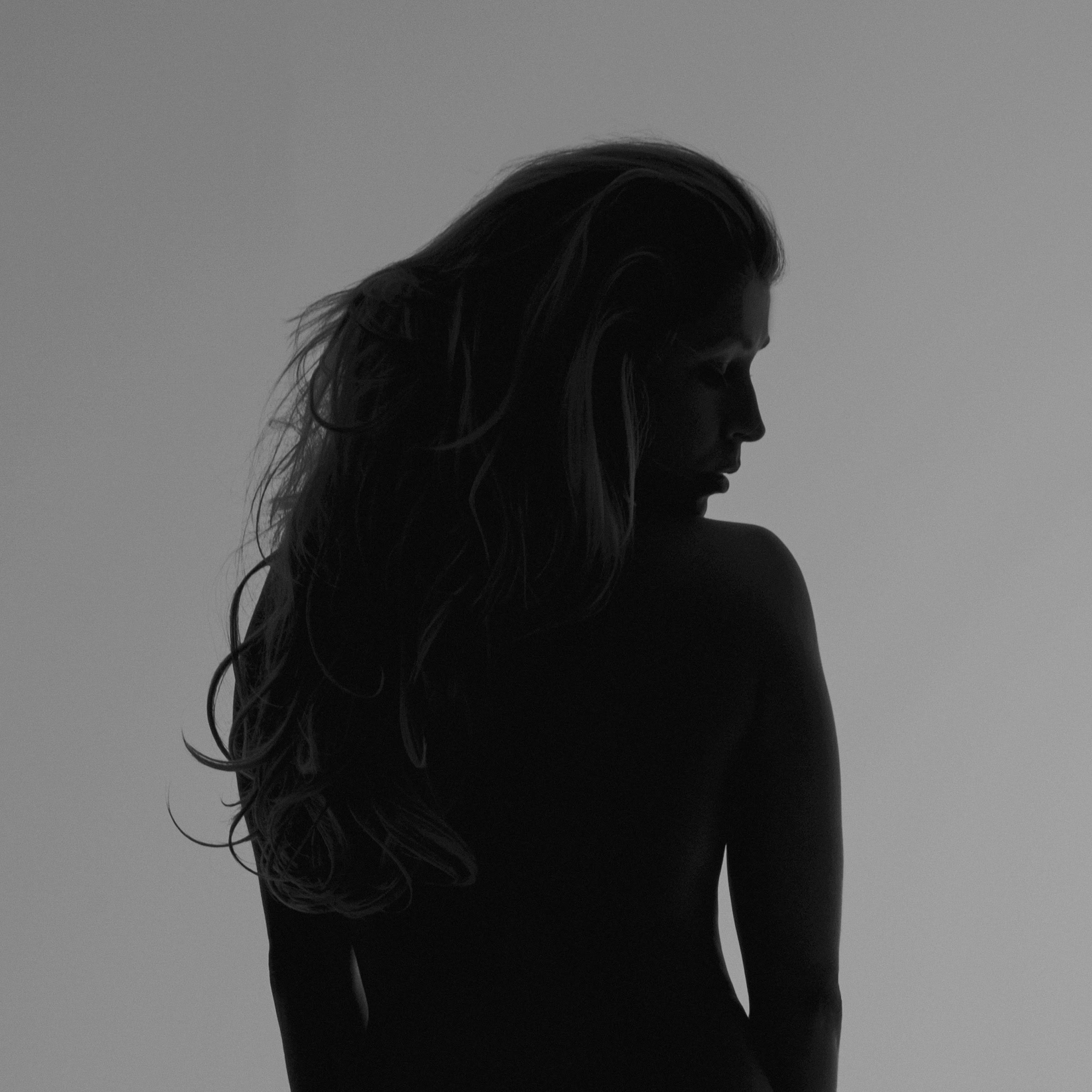 Figure standing, turned away, long hair