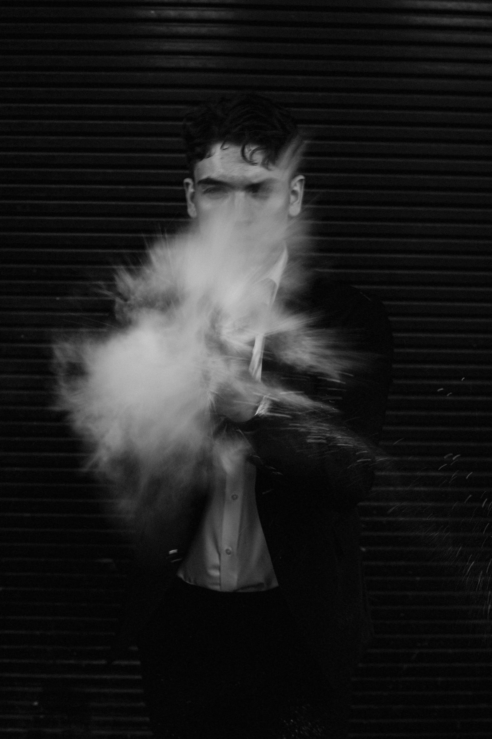 Face disappearing behind a burst of white powder